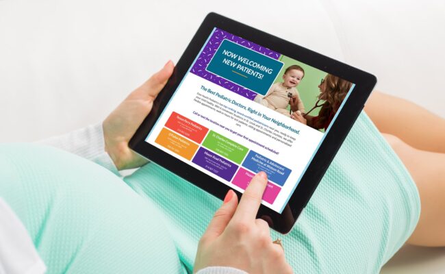 close up of pregnant person's hands holding an iPad displaying Esse Health Pediatrics webpage.